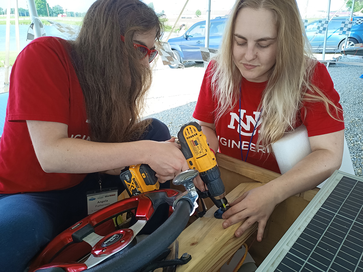 photo: two women students working on the boat